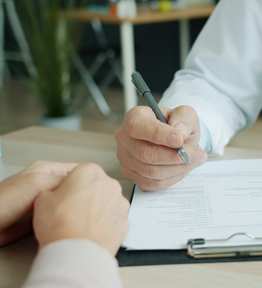 Seo Spravato - Doc-Rep A doctor filling out a patient chart during a consultation